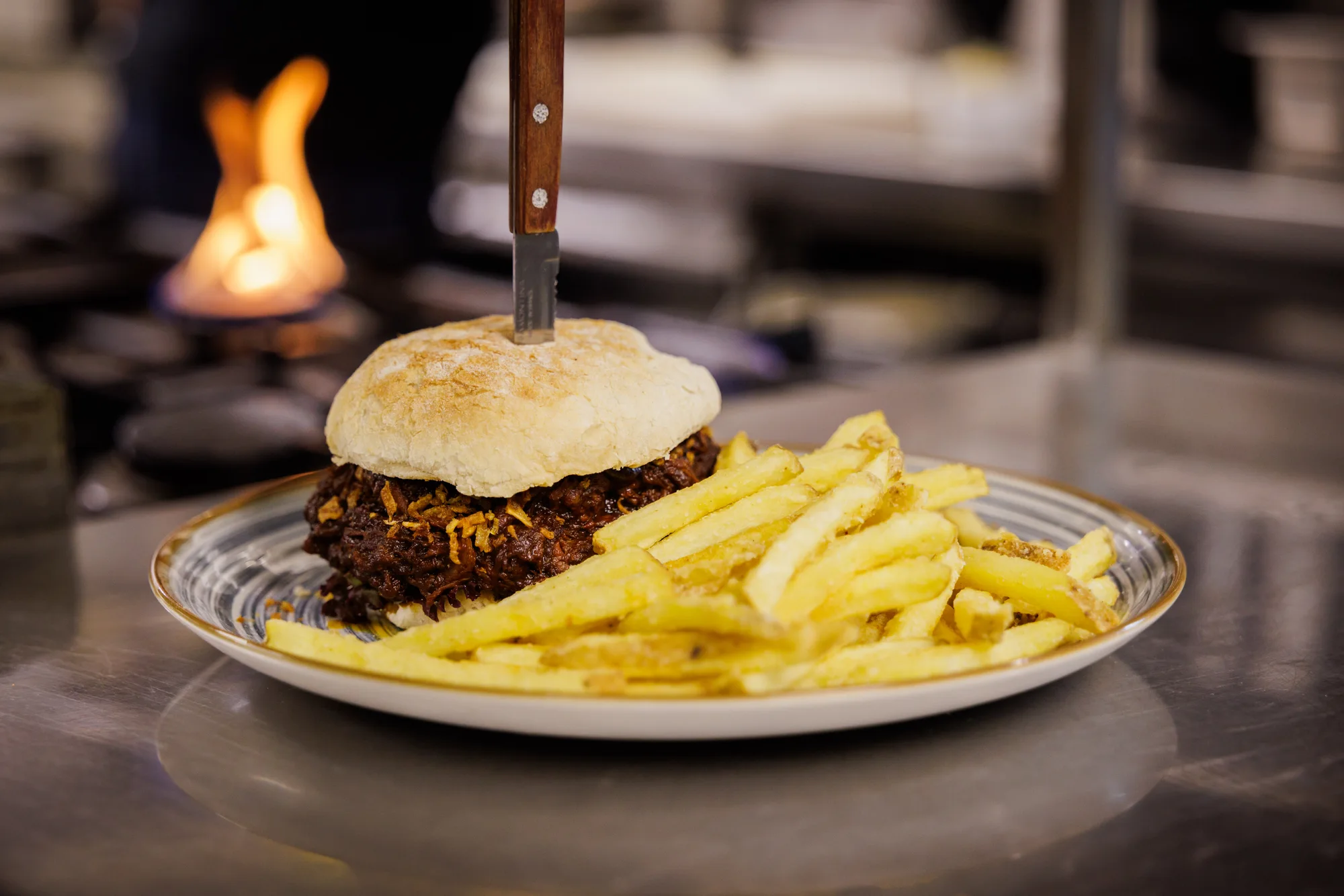 Burger mit Pommes, frisch angerichtet in der Brauhausküche